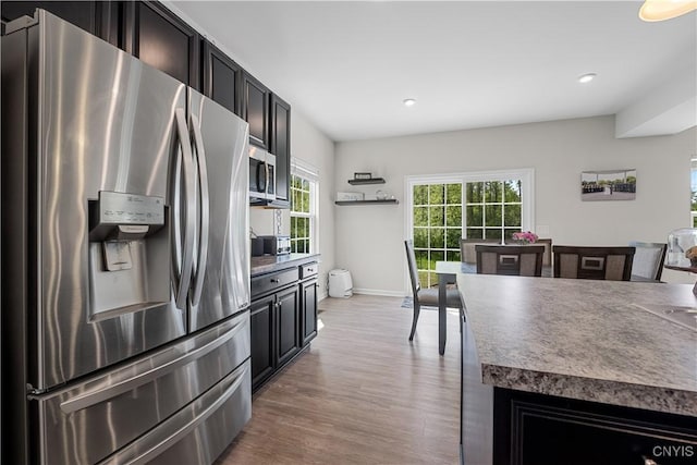 kitchen with stainless steel appliances, wood finished floors, recessed lighting, baseboards, and dark cabinets