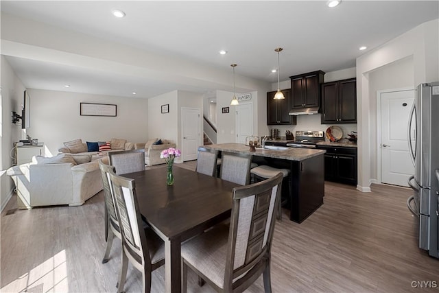 dining space with stairway, light wood finished floors, baseboards, and recessed lighting