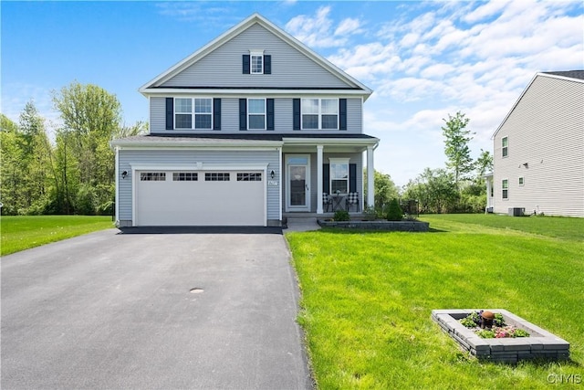 traditional-style house featuring a garage, driveway, a front lawn, and covered porch