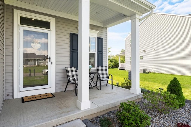 property entrance with covered porch and a lawn
