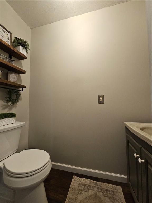 4862 Cross St, Campbell, NY 14821 - half bath featuring wood finished floors, toilet, baseboards, and vanity