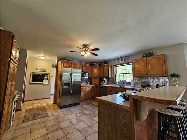4862 Cross St, Campbell, NY 14821 - kitchen featuring stainless steel appliances, a peninsula, a breakfast bar, ceiling fan, and brown cabinets