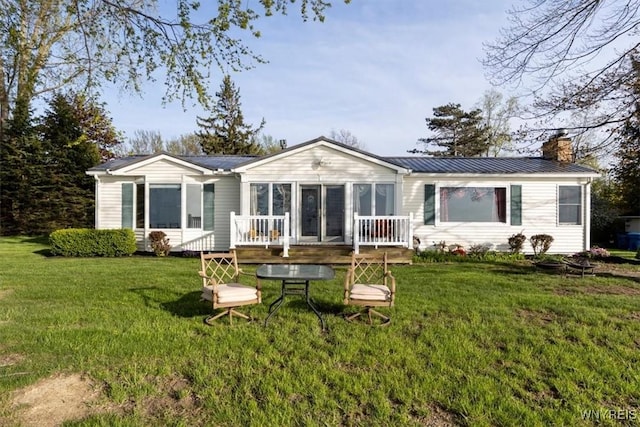 9910 Shorecliff Rd, Evans, NY 14006 - back of property with a chimney, a wooden deck, a yard, and metal roof