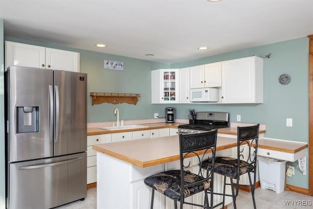 9910 Shorecliff Rd, Evans, NY 14006 - kitchen featuring appliances with stainless steel finishes, a sink, light countertops, white cabinetry, and glass insert cabinets