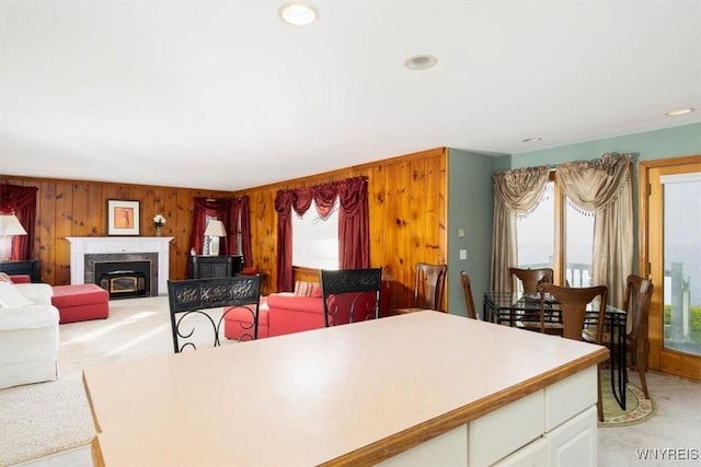 9910 Shorecliff Rd, Evans, NY 14006 - dining room with light colored carpet, wood walls, a high end fireplace, and recessed lighting