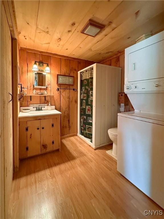 123 Mohawk Dr W, Webb, NY 13420 - bathroom with stacked washer and clothes dryer, wooden ceiling, wood finished floors, toilet, and vanity