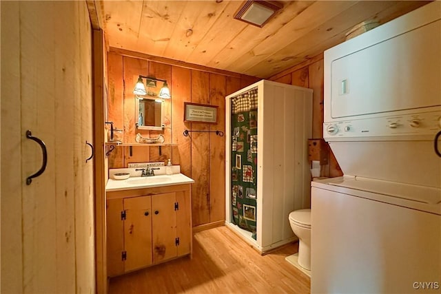 123 Mohawk Dr W, Webb, NY 13420 - bathroom with stacked washer / drying machine, wood finished floors, wood ceiling, wood walls, and toilet