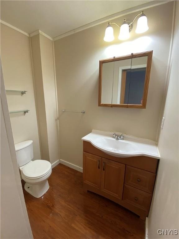 533 Mundy St, Watertown-City, NY 13601 - bathroom featuring wood finished floors, vanity, toilet, crown molding, and baseboards