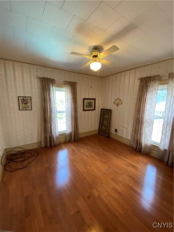 533 Mundy St, Watertown-City, NY 13601 - unfurnished room with light wood-style flooring, wallpapered walls, a ceiling fan, and baseboards