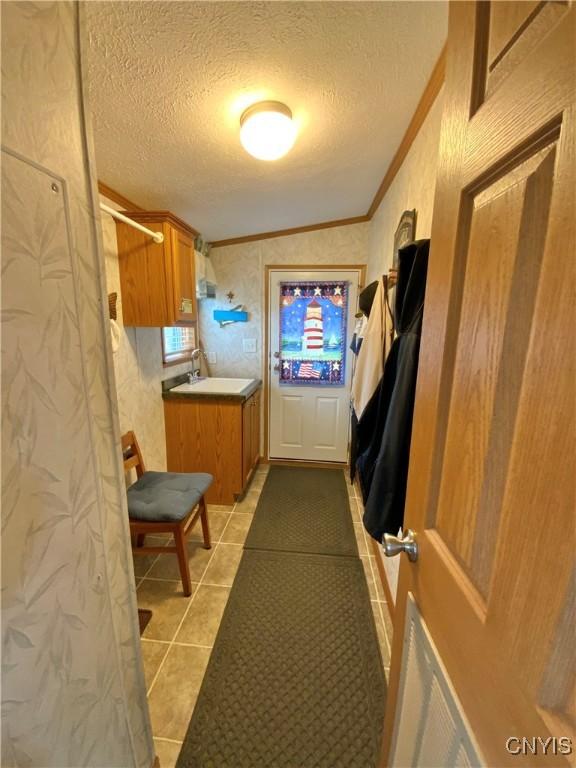 2570 Humphrey Rd, Cape Vincent, NY 13618 - mudroom featuring crown molding, a textured ceiling, light tile patterned floors, and a sink
