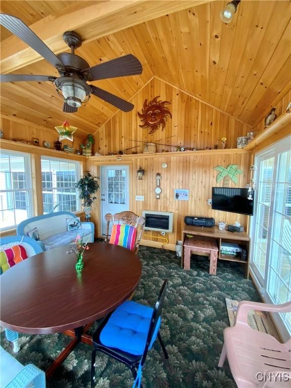 2570 Humphrey Rd, Cape Vincent, NY 13618 - dining space with vaulted ceiling, wooden walls, wooden ceiling, carpet, and ceiling fan
