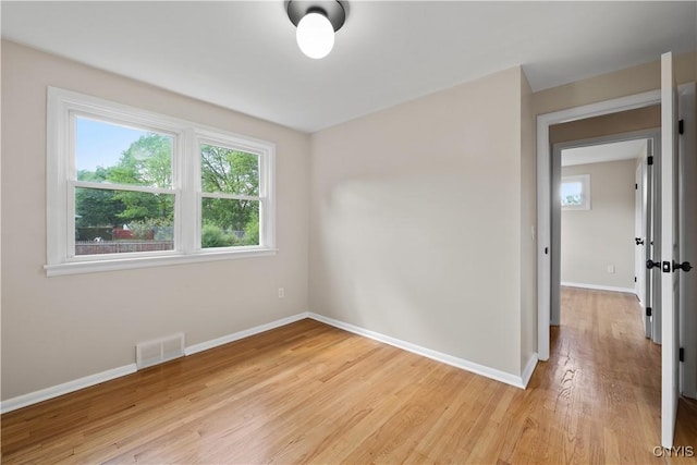 unfurnished room with light wood finished floors and baseboards