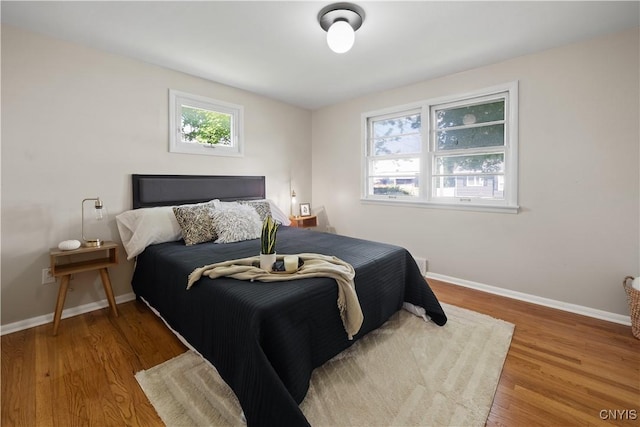 bedroom featuring baseboards and wood finished floors