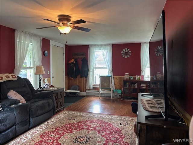 158 E Main St, Concord, NY 14141 - living area featuring a ceiling fan, wood finished floors, and a wainscoted wall