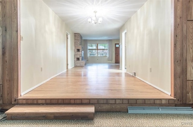 115 Stafford Dr, Rutland, NY 13612 - hallway with wood finished floors, a chandelier, and baseboards