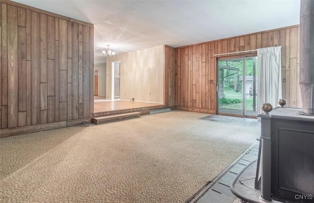 115 Stafford Dr, Rutland, NY 13612 - carpeted living area featuring wood walls, a chandelier, and baseboards