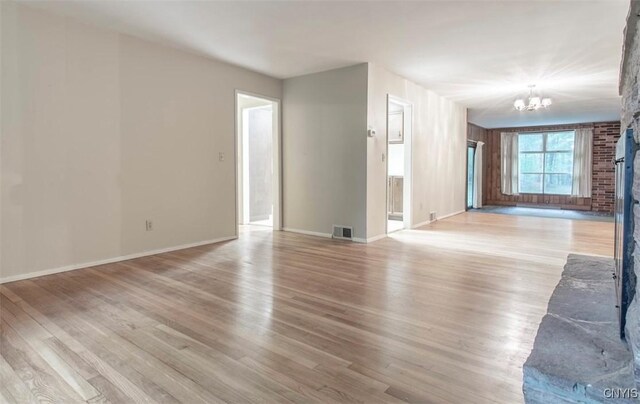 115 Stafford Dr, Rutland, NY 13612 - unfurnished living room with a chandelier, baseboards, and light wood-style flooring