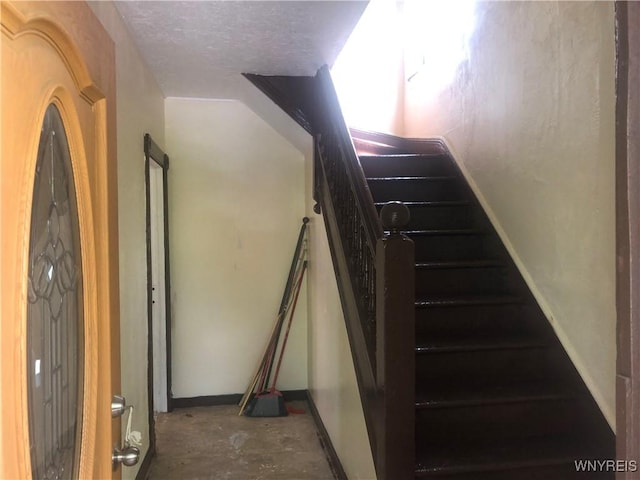 515 9th St, Niagara Falls, NY 14301 - staircase with concrete flooring, a textured ceiling, and baseboards