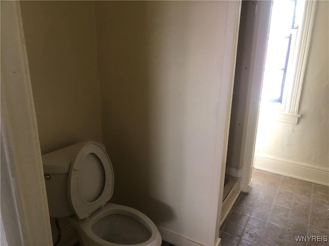515 9th St, Niagara Falls, NY 14301 - bathroom with toilet, baseboards, a shower, and stone finish floors
