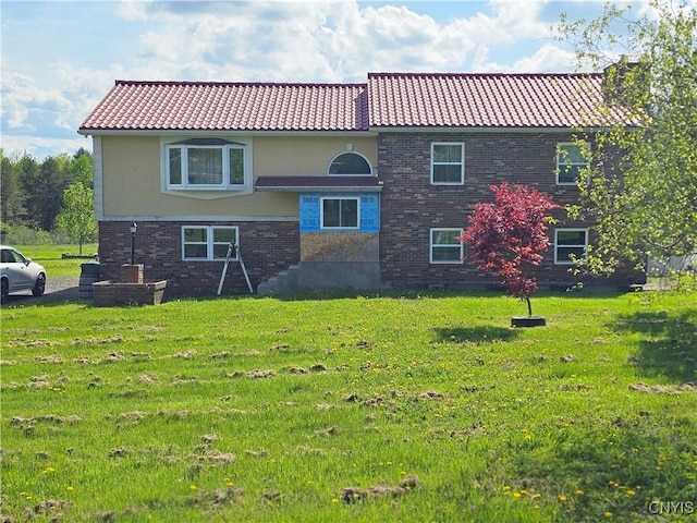 5813 Grace Rd, Deerfield, NY 13502 - rear view of property featuring a tile roof, a lawn, and brick siding