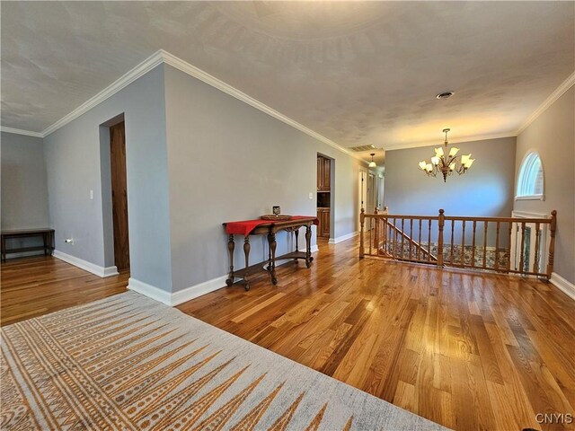 5813 Grace Rd, Deerfield, NY 13502 - spare room featuring wood-type flooring, a chandelier, baseboards, and crown molding