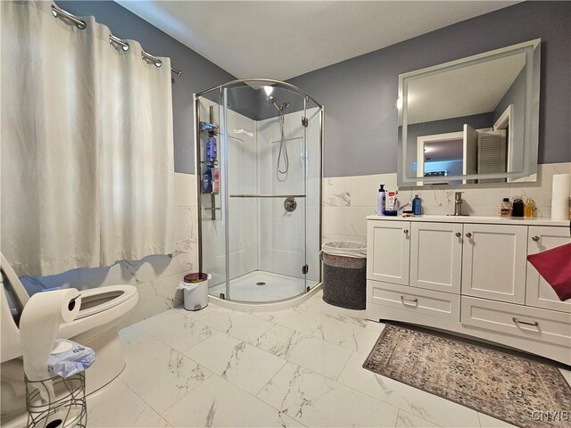 5813 Grace Rd, Deerfield, NY 13502 - bathroom with tile walls, a stall shower, marble finish floors, vanity, and a wainscoted wall