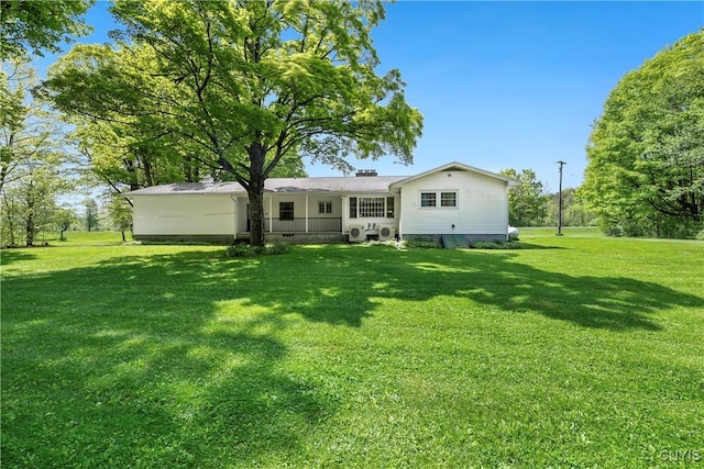 rear view of property with a yard
