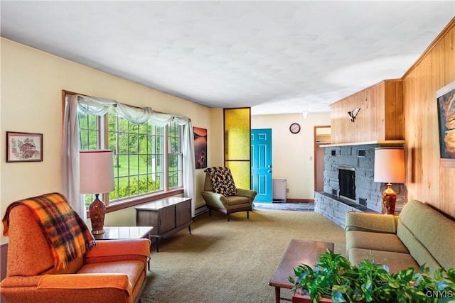 living room with carpet floors, a fireplace, wood walls, and a baseboard radiator
