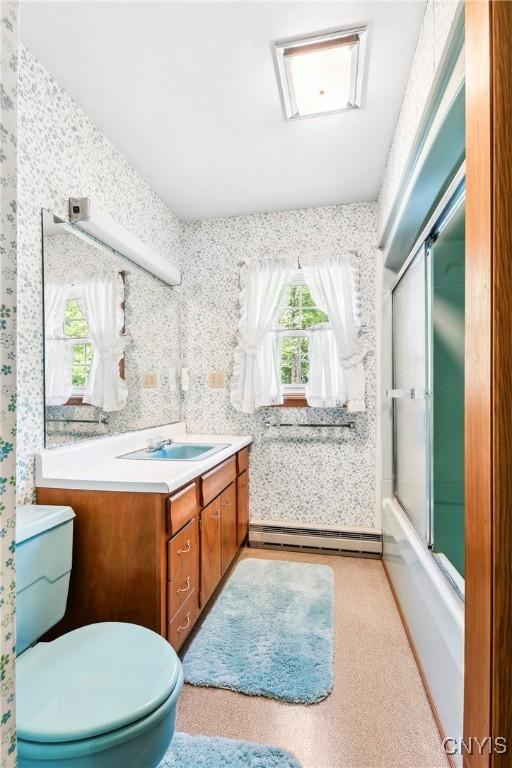 full bathroom featuring a baseboard radiator, wallpapered walls, toilet, vanity, and enclosed tub / shower combo