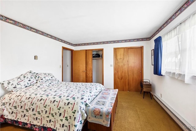 bedroom featuring baseboard heating, carpet floors, and two closets
