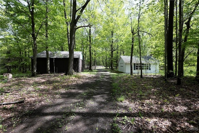 view of yard featuring a wooded view and an outdoor structure