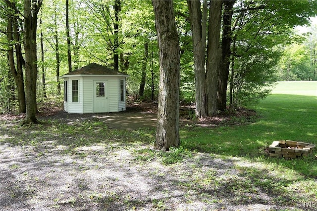 view of grassy yard with an outbuilding and a storage unit