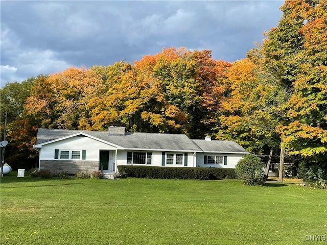 single story home featuring a front yard, stone siding, and a chimney