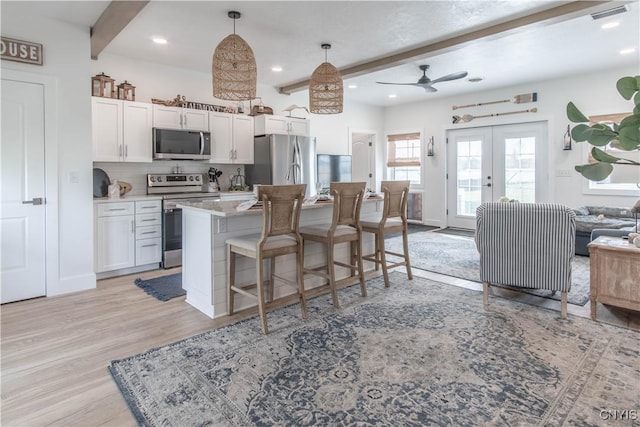 26618 Three Mile Point Rd, Lyme, NY 13622 - kitchen with appliances with stainless steel finishes, ceiling fan, french doors, beam ceiling, and white cabinetry
