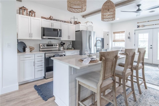 26618 Three Mile Point Rd, Lyme, NY 13622 - kitchen with stainless steel appliances, tasteful backsplash, a breakfast bar, an island with sink, and a sink