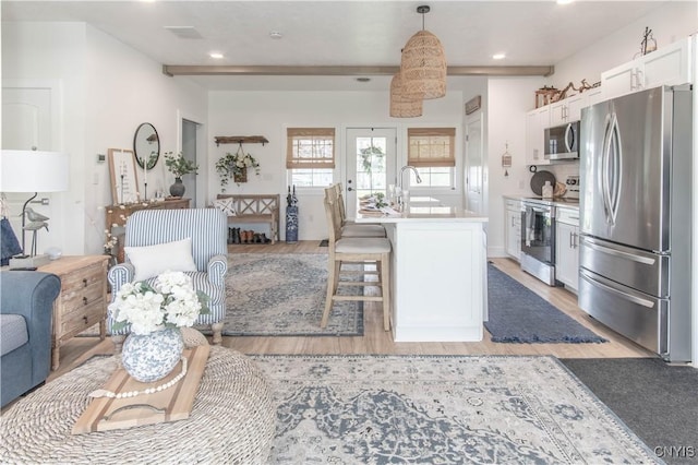 26618 Three Mile Point Rd, Lyme, NY 13622 - kitchen with stainless steel appliances, light wood-type flooring, a sink, white cabinets, and light countertops