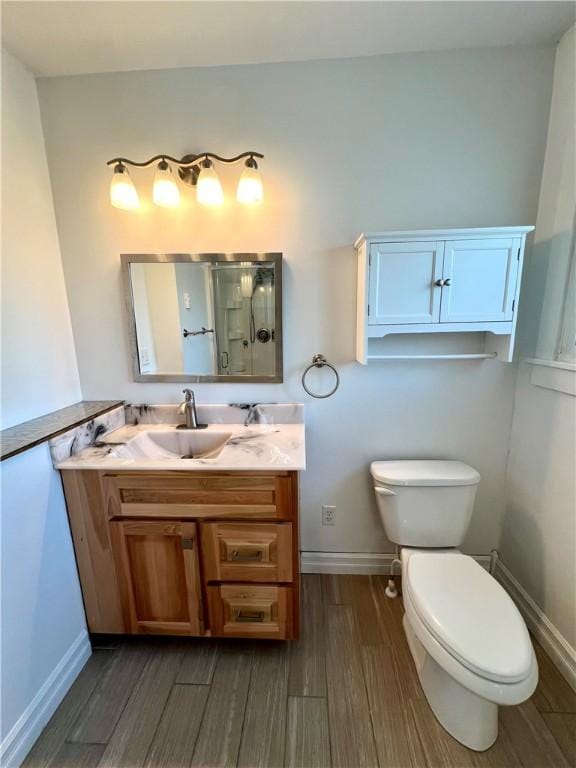808 Center St, Horseheads, NY 14845 - bathroom featuring wood finished floors, toilet, a shower stall, vanity, and baseboards
