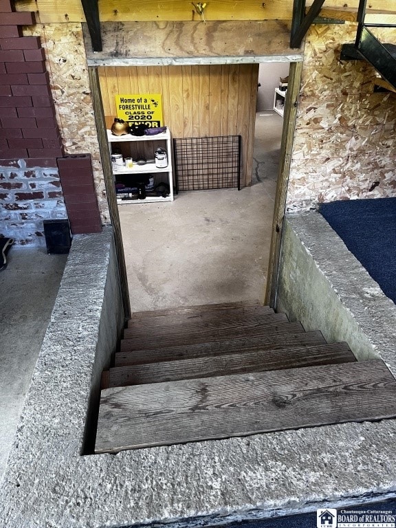 11604 York Rd, Hanover, NY 14136 - staircase with concrete flooring and wooden walls