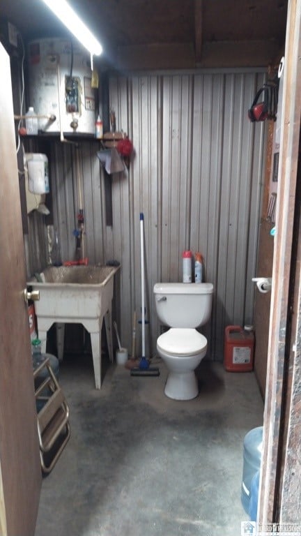 11604 York Rd, Hanover, NY 14136 - bathroom with concrete floors, toilet, and wood walls