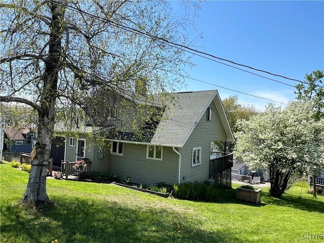2055 Fitzgerald Pt S, Otisco, NY 13110 - view of side of property featuring a lawn, a shingled roof, and a deck