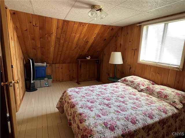2055 Fitzgerald Pt S, Otisco, NY 13110 - bedroom with hardwood / wood-style floors, wooden walls, lofted ceiling, and a ceiling fan