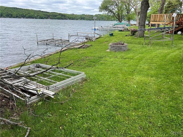 2055 Fitzgerald Pt S, Otisco, NY 13110 - view of green lawn with a boat dock, a fire pit, and a water view