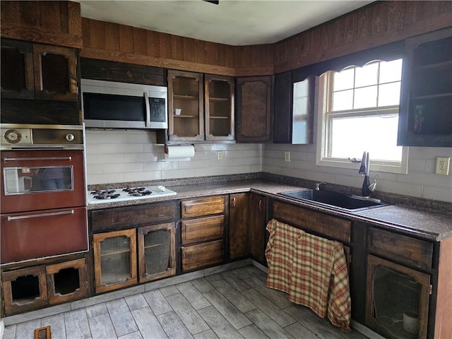 206 Pritchard Ave, Corning City, NY 14830 - kitchen featuring stainless steel microwave, white gas stovetop, a sink, glass insert cabinets, and light wood-style floors