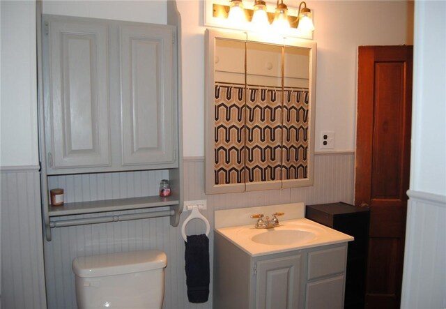 115 Lincoln St, Kane-Borough, PA 16735 - bathroom featuring a wainscoted wall, toilet, vanity, and a decorative wall