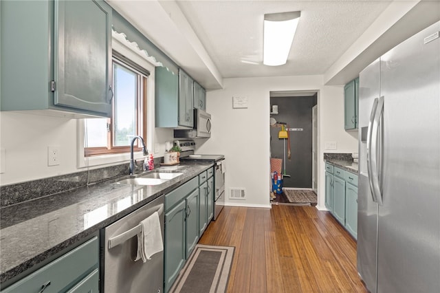 5904 Merrill Rd, Byron, NY 14422 - kitchen with stainless steel appliances, a sink, dark wood-style flooring, dark stone counters, and green cabinets