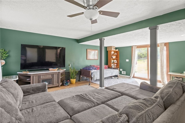 5904 Merrill Rd, Byron, NY 14422 - living room featuring a textured ceiling, ornate columns, wood finished floors, a ceiling fan, and baseboards