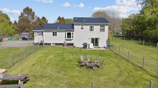 5904 Merrill Rd, Byron, NY 14422 - back of house with metal roof, a fire pit, and cooling unit