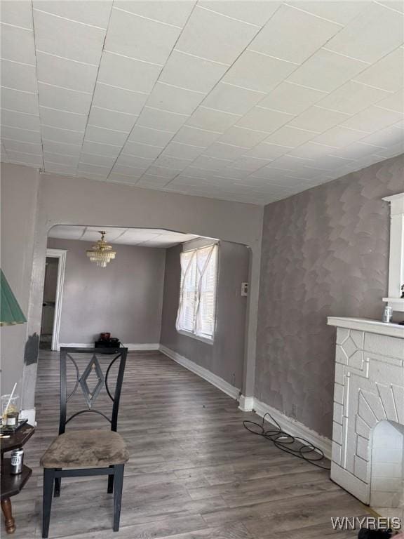 218 French St, Buffalo, NY 14211 - living room with baseboards, wood finished floors, and a chandelier