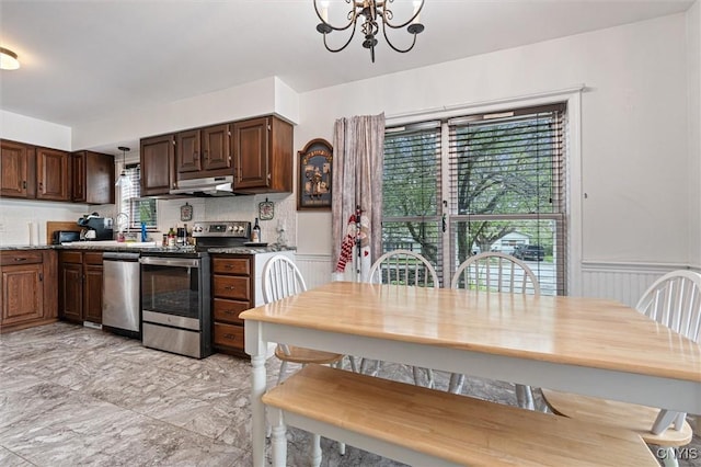 542 Lakeview Dr, Brownville, NY 13615 - kitchen featuring appliances with stainless steel finishes, a chandelier, a wainscoted wall, light marble finish flooring, and dark brown cabinetry