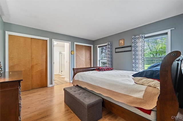 542 Lakeview Dr, Brownville, NY 13615 - bedroom with light wood-type flooring, multiple windows, ensuite bathroom, and baseboards